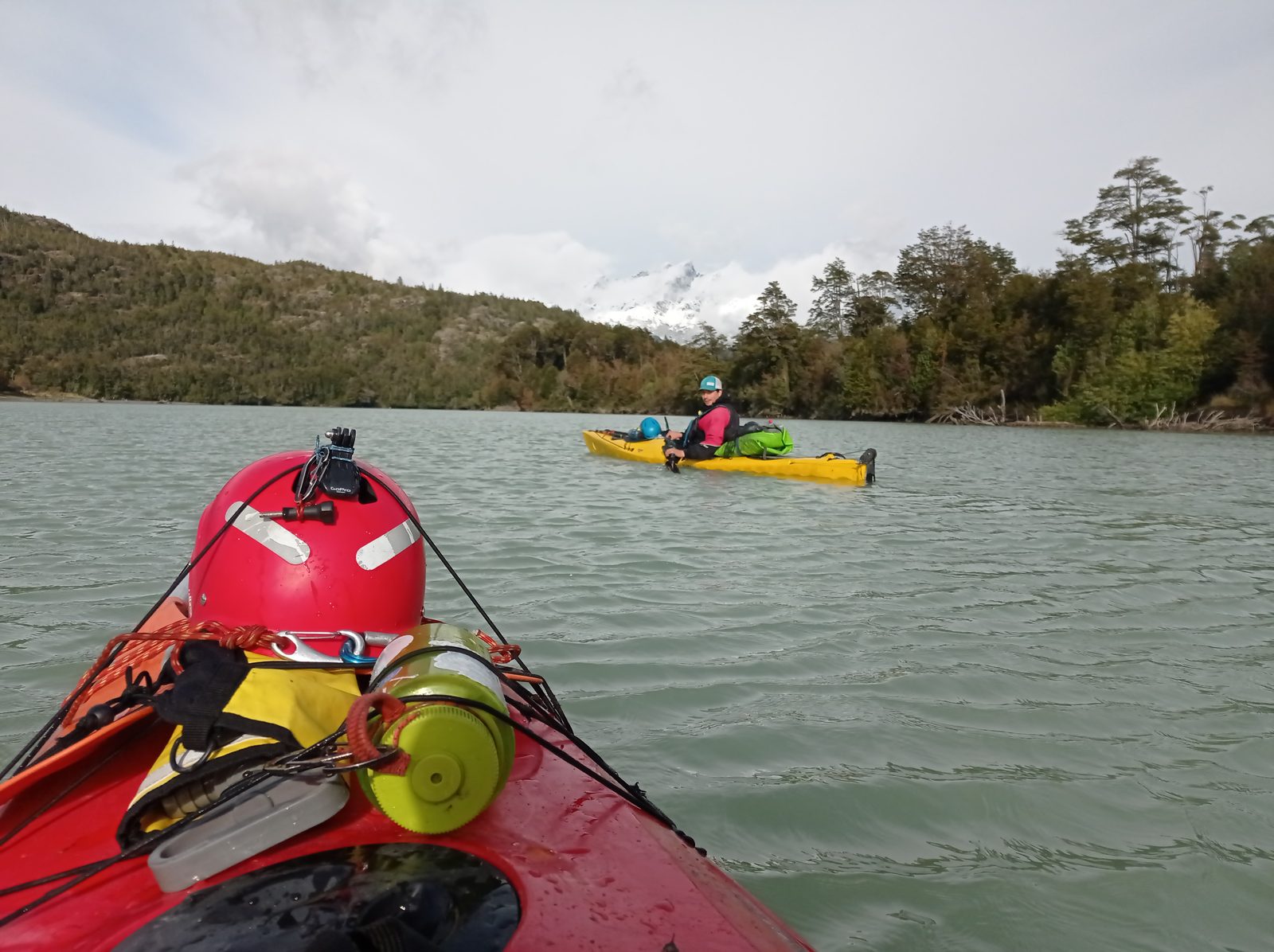 Kayaks en el Río Baker con montañas nevadas de fondo